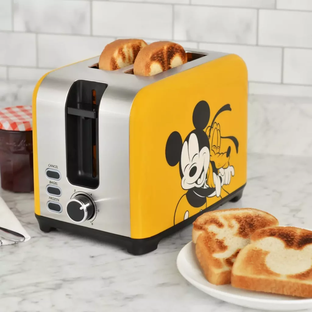 A yellow toaster with a Mickey and Pluto hugging on the side