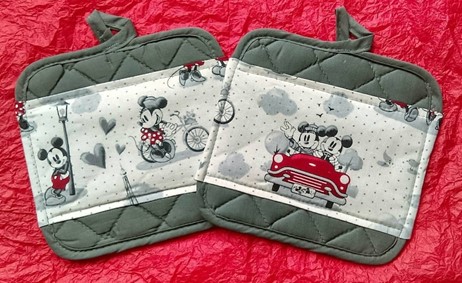 Two grey pot holders with images of Classic Minnie and Mickey mouse